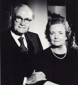Formally dressed older man and woman in black and white studio portrait.