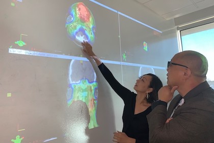 Drs. Mu-Han Lin and Steve Jiang look at a brain scan