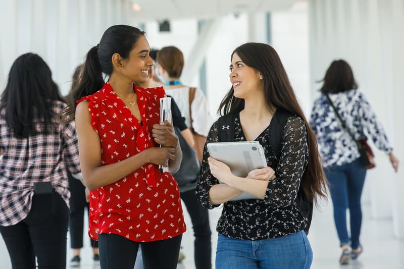 two students talking in a hallway