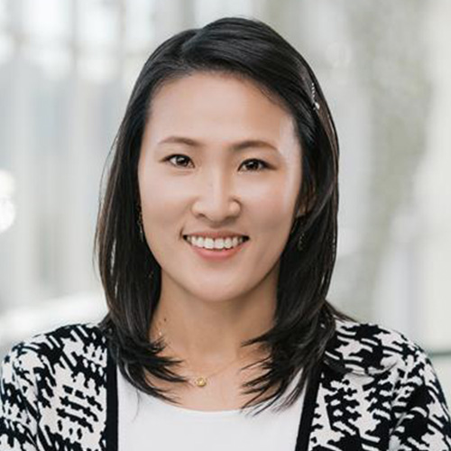 Woman with dark hair, wearing black and white blazer