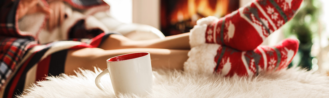 feet propped on cozy rug next to coffee mug and fireplace