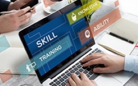 man's hand at laptop keyboard, display shows graphic overlay with text: skills, knowledge, training