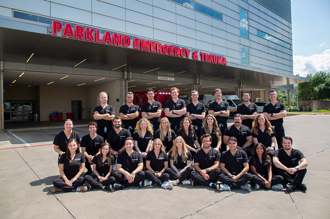 Large group of people posing for the camera in front of building