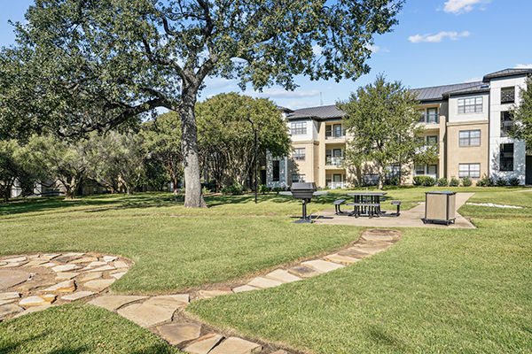 Grassy area with stepping stones, a grill and a picnic table