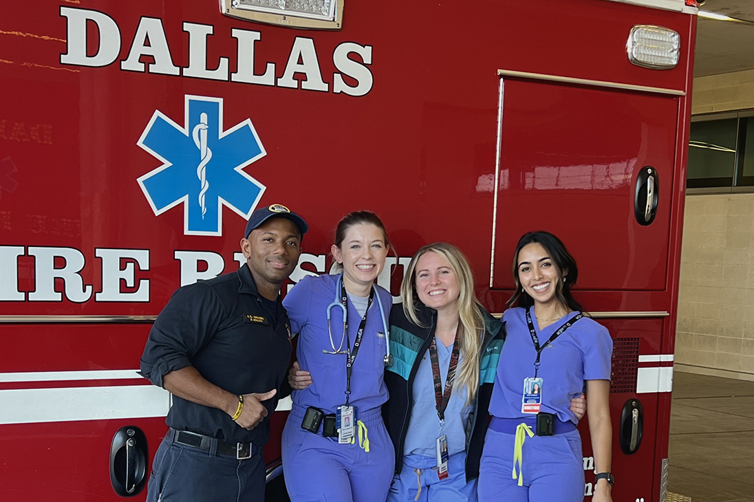 Four people posing in front of Dallas Fire Rescue truck