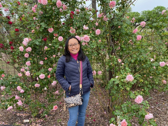 member of Faculty Women's Club poses in a flowering winter garden