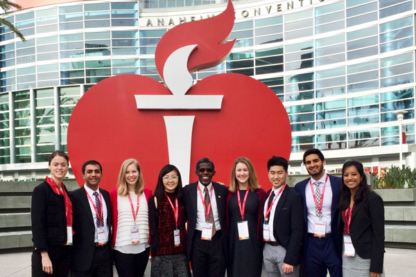 Jamie Pfaff and other Sarnoff Fellows in front of a large heart logo at the 2017 American Heart Association conference in Anaheim.