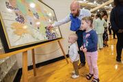 M’Kay Cauble places his headshot on the map as his kids watch.