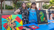 UTSW employee and artist Stephanie Hargrove, left, exhibits her creative pieces representing Hispanic culture.