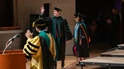David Zimmerhanzel, M.D., gives a big wave to the audience as he walks across the stage to receive his diploma.