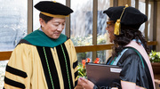 W. P. Andrew Lee, M.D., Executive Vice President for Academic Affairs, Provost, and Dean of UT Southwestern Medical School, and Carolyn Bradley-Guidry, Dr.PH., M.P.A.S., PA-C, Associate Dean for Student Affairs and Engagement – School of Health Professions, prepare for the students to walk across the stage.