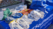 Gloves, hats, and hand warmers are available at an outdoor booth staffed by UTSW’s Office for Institutional Opportunity at the event.