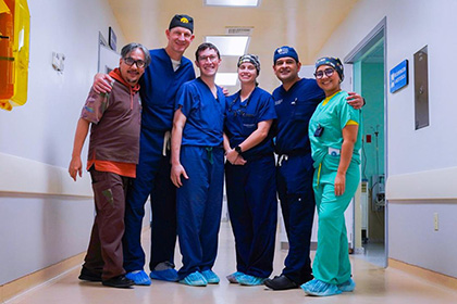 The team of 4 men and two women from UTSW dressed in surgical scrubs.