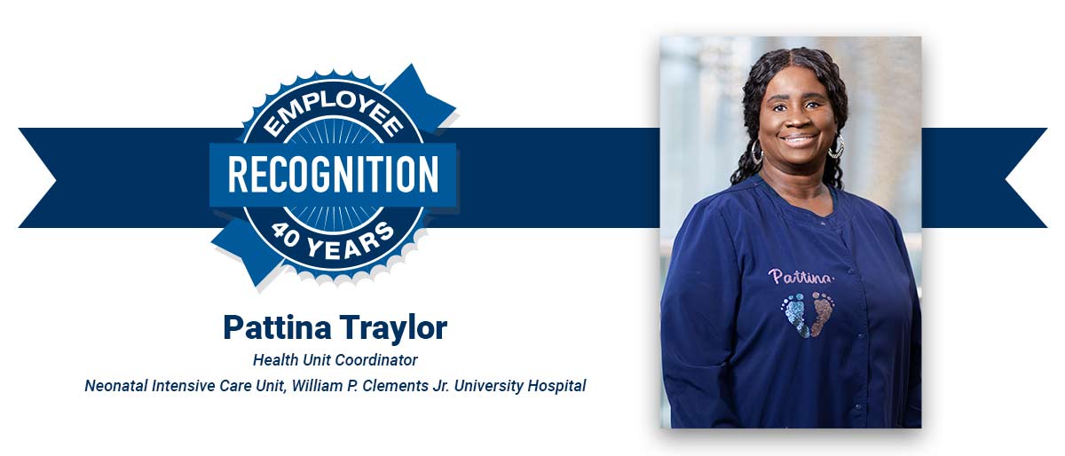 Smiling woman with long dark curly hair, wearing blue scrubs with her name, Pattina, and baby footprints painted on. On white banner with-Pattina Traylor, Health Unit Coordinator, Neonatal Intensive Care Unit, William P. Clements Jr. University Hospital, and blue Employee Recognition Program logo.