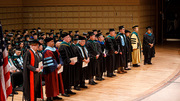 UTSW faculty in the Platform Party stand in recognition of the graduates.