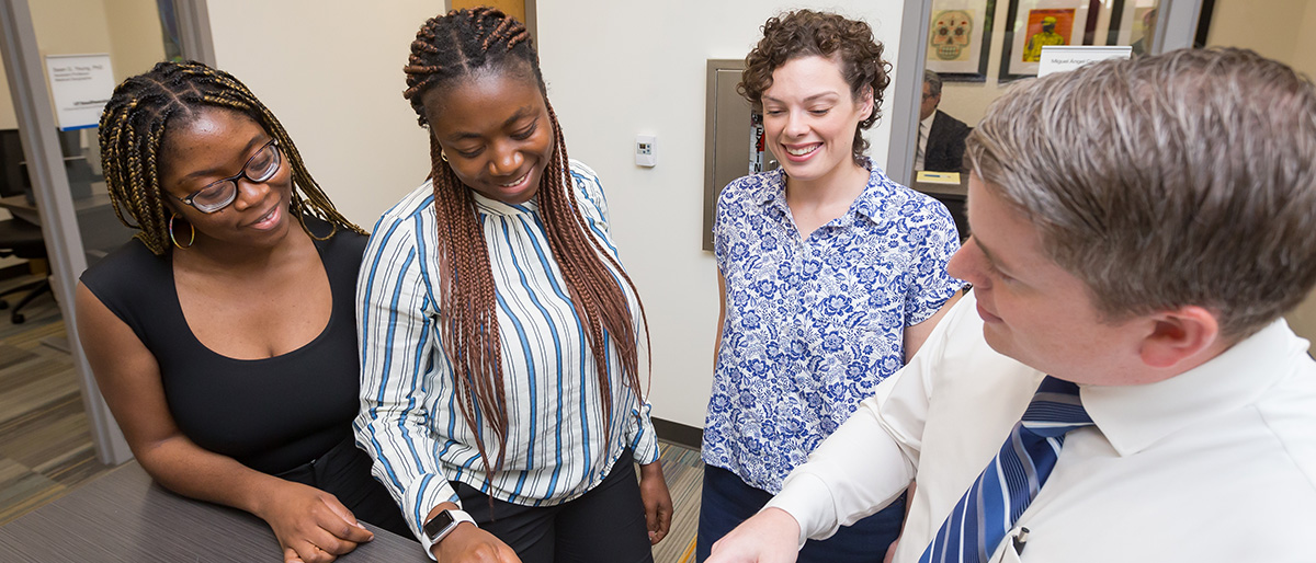 OSPH students visiting with a faculty member at orientation.