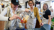 Katy Yost, left, a member of UT Southwestern’s Young Adult Cancer Support group, makes creamy pumpkin hummus during a cooking class in mid-November with the help of UTSW registered dietitians Darienne Hall, center, and Kathryn Kanter. The Harold C. Simmons Comprehensive Cancer Center group provides an outlet for cancer patients ages 18 to 39 to socialize and receive assistance during their health journey.