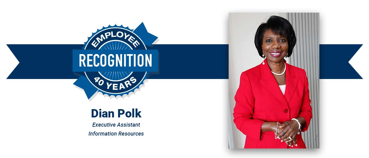 Smiling woman with short dark hair, wearing a striking red suit and pearls. On white banner with-Dian Polk, Executive Assistant, Information Resources, and blue Employee Recognition Program logo.