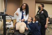 Sandy Page, a clinical volunteer for the day, shows Ella Jones and Fromee Menegesha how to use the ultrasound machine.