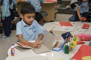 A student brings out the crayons to decorate his card.