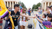 UTSW employees Paul Yu-Angel (left), Certified Oncology Outpatient Chaplain for the Harold C. Simmons Comprehensive Cancer Center, and Dawn Cureton, Director of the Office for Institutional Opportunity, hand out festive flags to happy paradegoers.