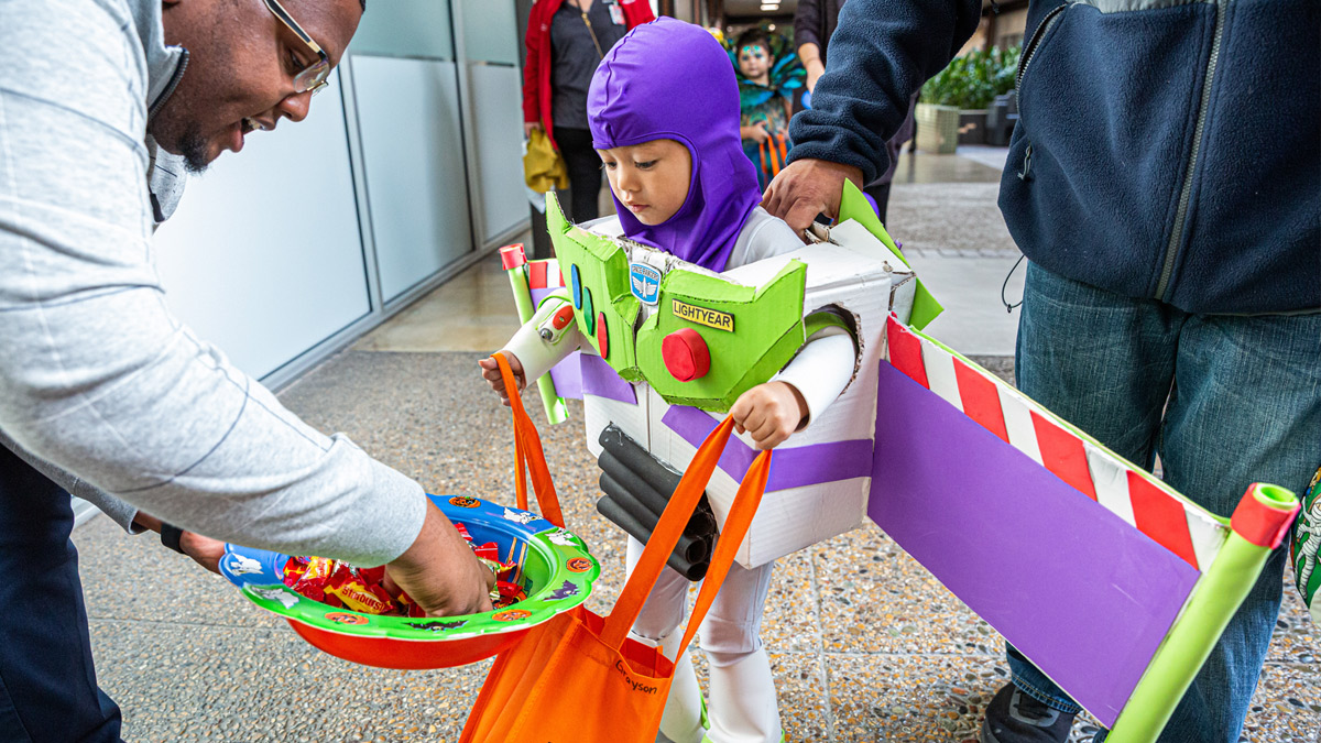 Child dressed as Buzz Lightyear getting candy