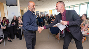 Russell Poole, M.B.A., Vice President of Information Resources and Chief Information Officer, greets Gold pin recipient and Technical Supply Specialist III Raed Jaber as he receives his certificate at a PACT Platinum and Gold Celebration in April. UTSW team members earned 966 PACT Gold and Platinum pins for exceptional customer service in the most recent calendar year.