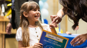 Savannah Smith, a student at Biomedical Preparatory at UT Southwestern, is all smiles after receiving her certificate at the end-of-the year award ceremony in May. The school, which opened on North Campus in 2022 through a partnership between UTSW and the Dallas Independent School District, focuses on science, technology, engineering, and mathematics.