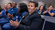 Emebet Dubale, one of the Platinum pin honorees, enjoys the ceremony as other attendees cheer in the background.