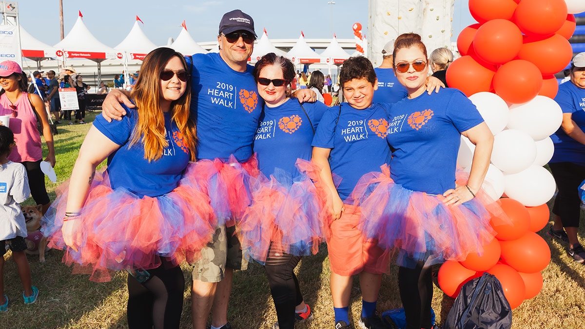 Five people in blue shirts and red tutus attending the Heart Walk