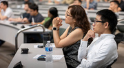 Jinfan Wang, Ph.D., Assistant Professor of Biochemistry (right), focuses on fellow presenters’ research at the event.