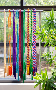Colorful graduation cords represent each of the Academic Colleges, members of the Gold Humanism Honor Society, the AOA Medical Society, and the U.S. Armed Forces Active Duty and Veterans.