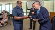 David Nelson of the Talent Development team presents Gold pin recipient Fredrick Frost with his certificate.