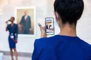 A health care staff member captures video of the performance.