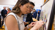 Marilyn Lu and her father place her photo on the map where she will be completing her residency.