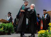 Medical School 2019 Co-Class President Dr. Reed Macy goes in for a hug on stage.