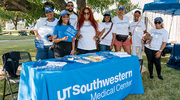 The UTSW community poses with a table full of treats at the Dallas event.
