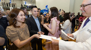 Aundree Hermawan (left) and Jorena Kim receive their match envelopes from a faculty member.