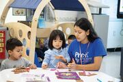 A teacher works with students, explaining the day’s current science-based interactive project.