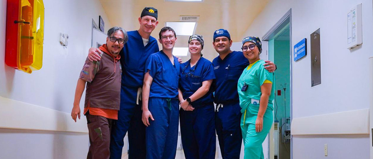 The team of 4 men and two women from UTSW dressed in surgical scrubs.