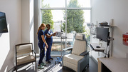 RNs Kathryn Gagnon (left) and Niki Greenwood test out equipment in an infusion treatment room that looks out into the open-air atrium.