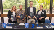 From left: Symposium team members Diana DiLolle, Senior Program Coordinator, Office of the Provost; Jennifer Azares, Executive Assistant to Dr. Lee; Michael Baker, Manager of Clinical Sciences – Academic Affairs; and Mikki Norris, Executive Assistant, Office of the Provost; share the latest UT Southwestern research report at the registration desk.
