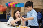 This young boy asks for a little help putting his yarn together for the project.