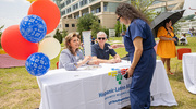 An employee visits the Hispanic-Latino Alliance BRG table to chat and snag a little swag.