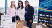 From left: Clinical Research Coordinator Andrea Flaten, Clinical Research Assistant I Kennedy Stone, and Clinical Research Coordinator I Alyssa Truxon visit the Office of Community Health and Research Engagement table at the CRP celebration.