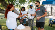 A UTSW volunteer shares free swag with Juneteenth 4K Walk and Festival attendees in Dallas.