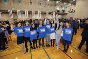 Students cheer with their blue shirts.