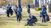 Participants work on one street, picking up litter from a grassy area.