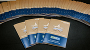 A spread of PACT Platinum and Gold pin celebration event programs