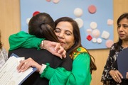 Ms. Ali shares a hug with Sherri Wood Cooper, Manager of Volunteer Services at UT Southwestern.